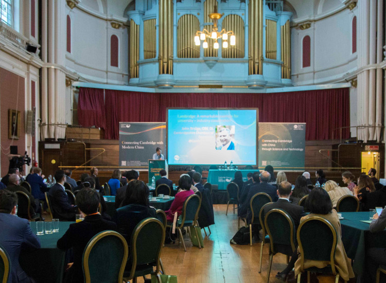 Speaker on stage at a large event in the Guildhall in Cambridge