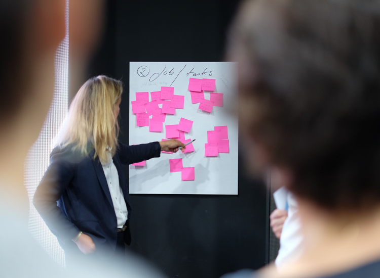 Woman pointing at post-its on a wall